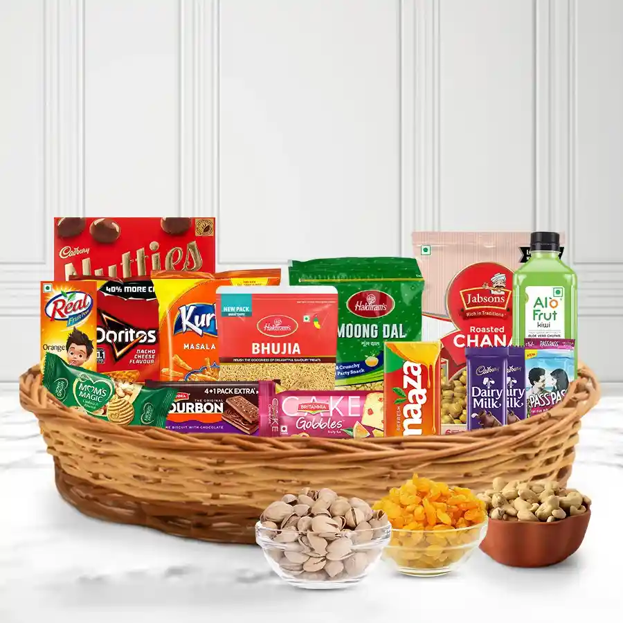 A heavenly snack hamper for Mom filled with delicious treats, including chips, sweets, and refreshing juices, beautifully arranged in a cane basket.