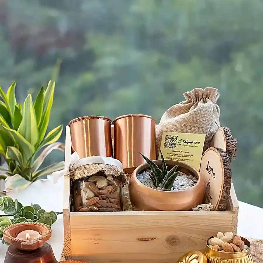 Eco-friendly love basket featuring copper glassware, coasters, dry fruits, a planter, potpourri, and a personalized pinewood box.
