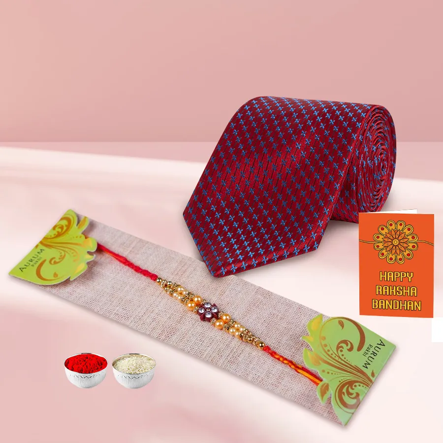Beautiful Silken Raymond Tie with a colorful Rakhi, Roli Tilak, and Chawal, elegantly presented for Raksha Bandhan celebration.