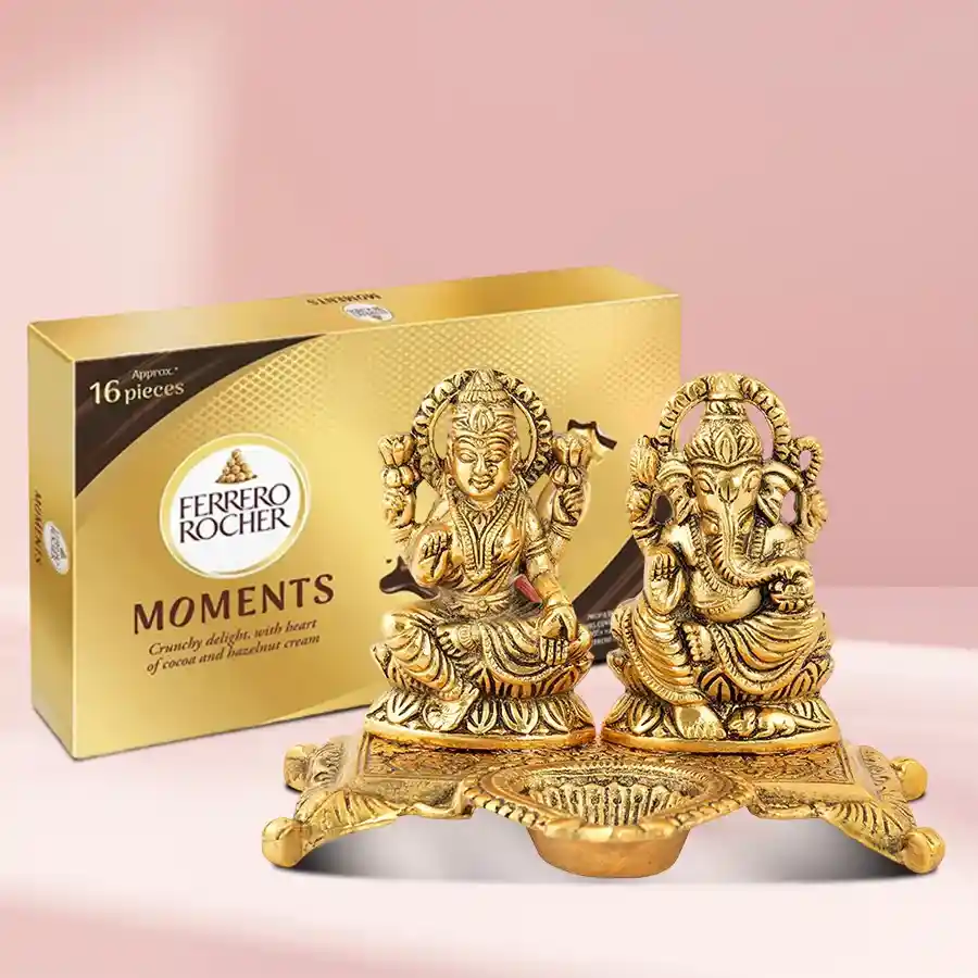 Festive gold Laxmi Ganesh idol with oil lamp diya and Ferrero Rocher chocolates for Diwali celebration.