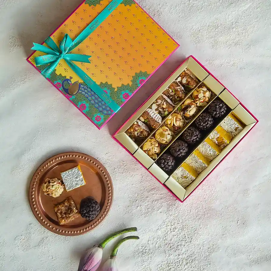 Kesar's 500g assorted sweets box featuring Dodha Barfi, Moong Thal, and Chocochip Laddoos.