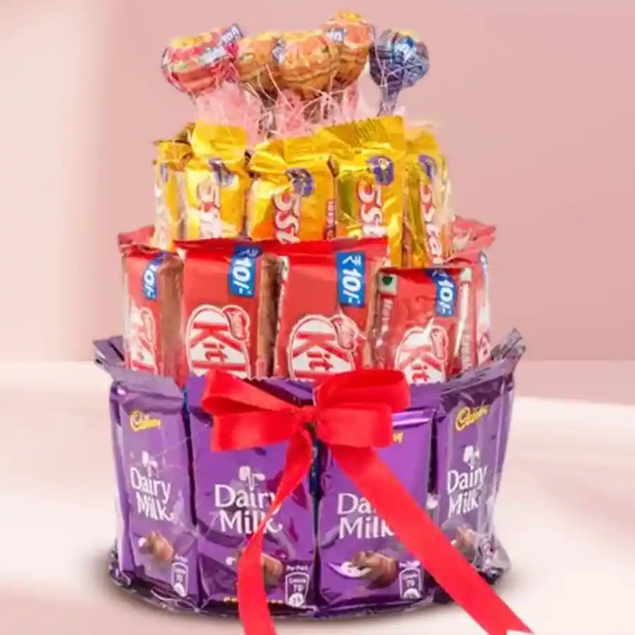 Indulgent 4 Layer Chocolate Delight Tower with Kitkat, Cadbury chocolates, and Chupa Chup lollipops elegantly tied with a ribbon.