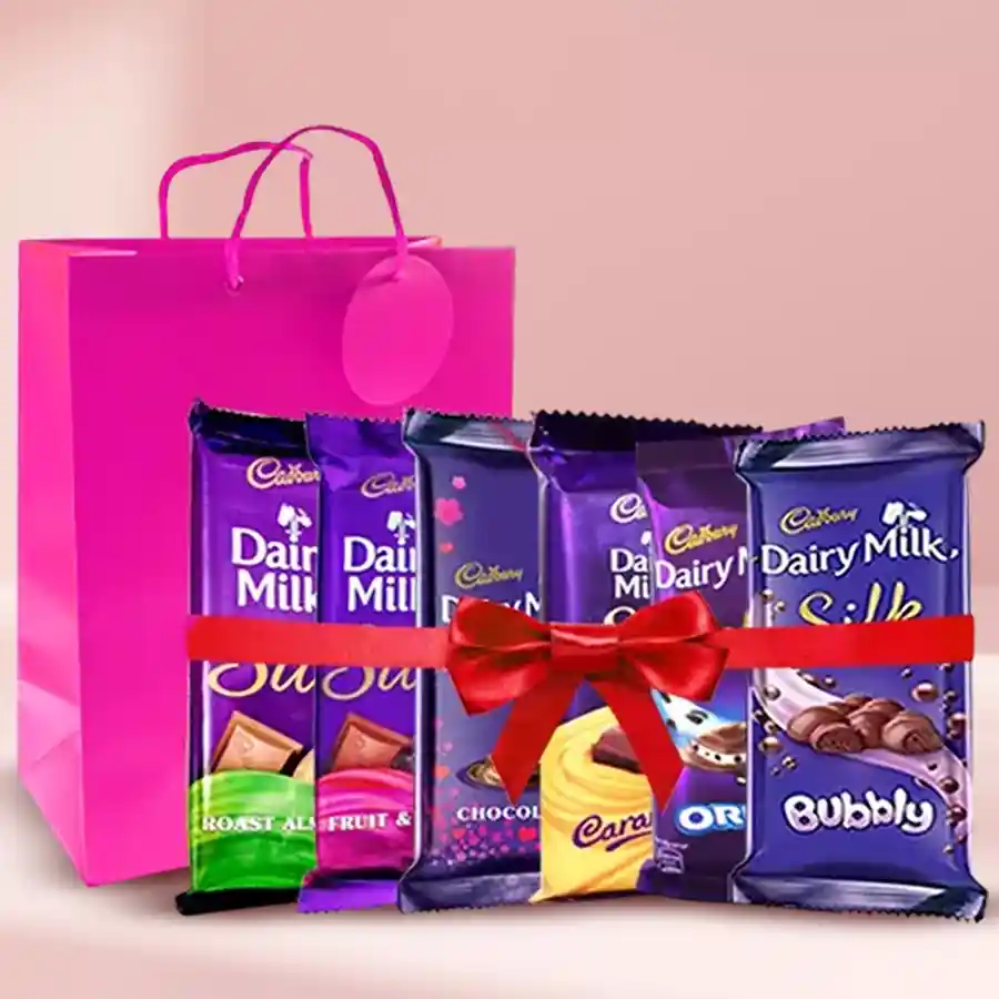 Cadbury Dairy Milk Sweet Indulgence Collection in a red handbag, featuring multiple flavors and elegantly tied with a satin ribbon.