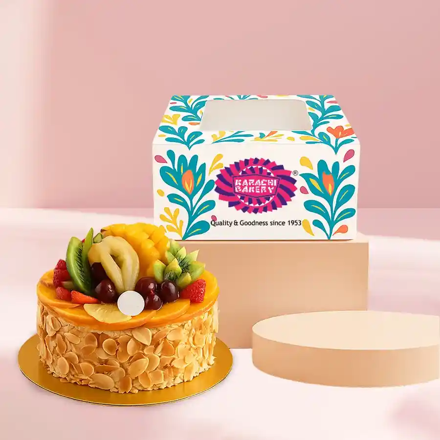 A 1 lb Fresh Fruit Cake from Karachi Bakery, featuring a fluffy sponge base topped with creamy frosting and vibrant fresh fruits.