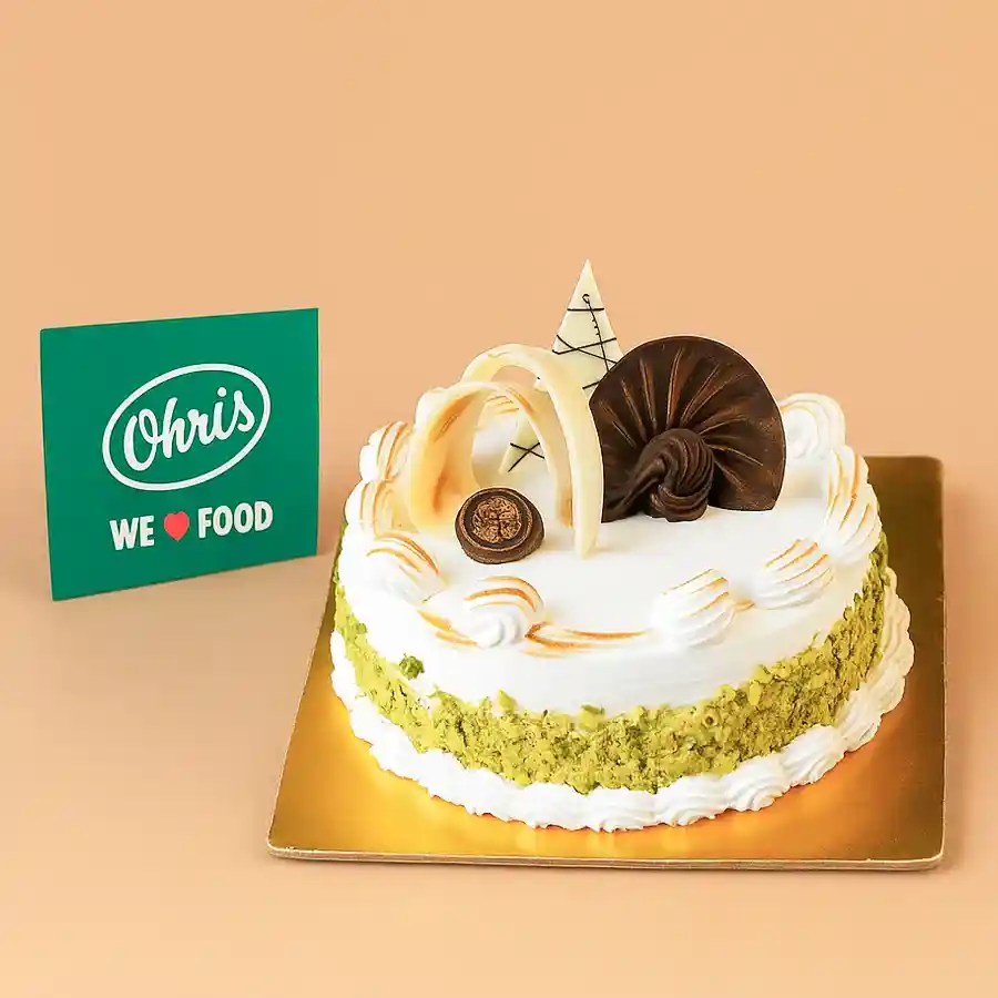 A beautifully decorated Vanilla Rasmalai Cake, featuring fluffy layers and sweet cardamom essence, perfect for special occasions.