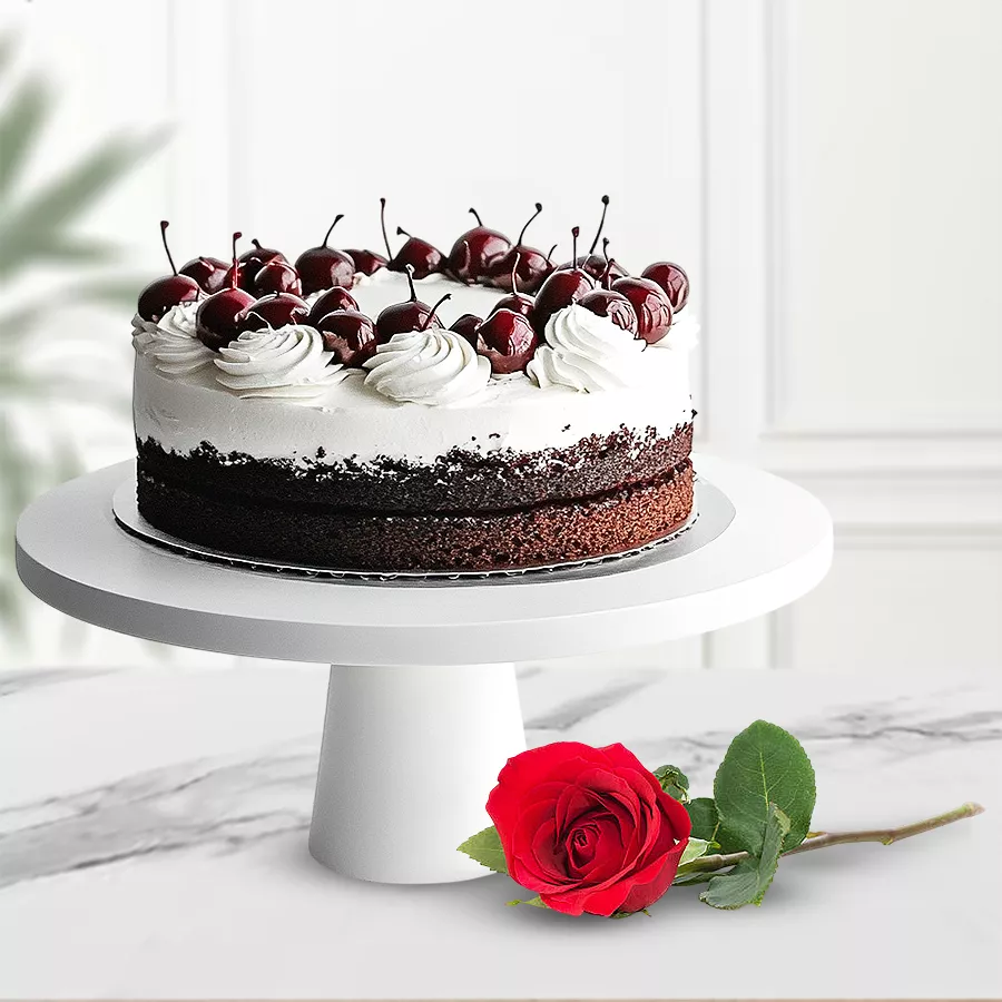 A rich eggless Black Forest cake accompanied by a single rose, perfect for heartfelt gifting.