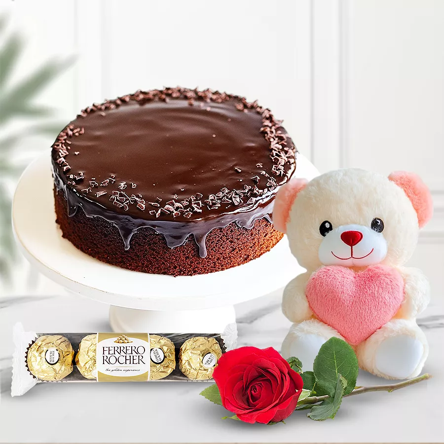 Eggless chocolate cake with a red rose, Ferrero Rocher, and a teddy bear in an elegant gift combo.