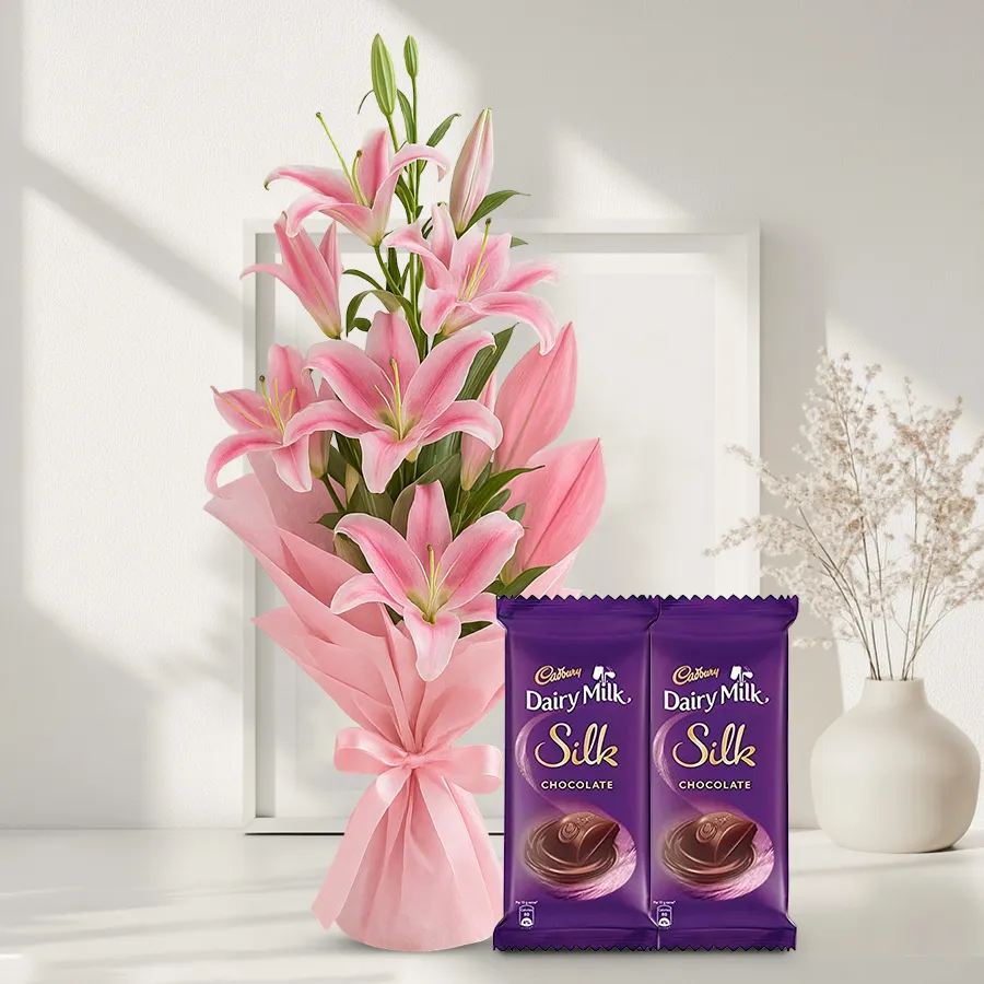 A luxurious bouquet of pink lilies accompanied by Cadbury Dairy Milk Silk chocolates, ideal for gifting on special occasions.