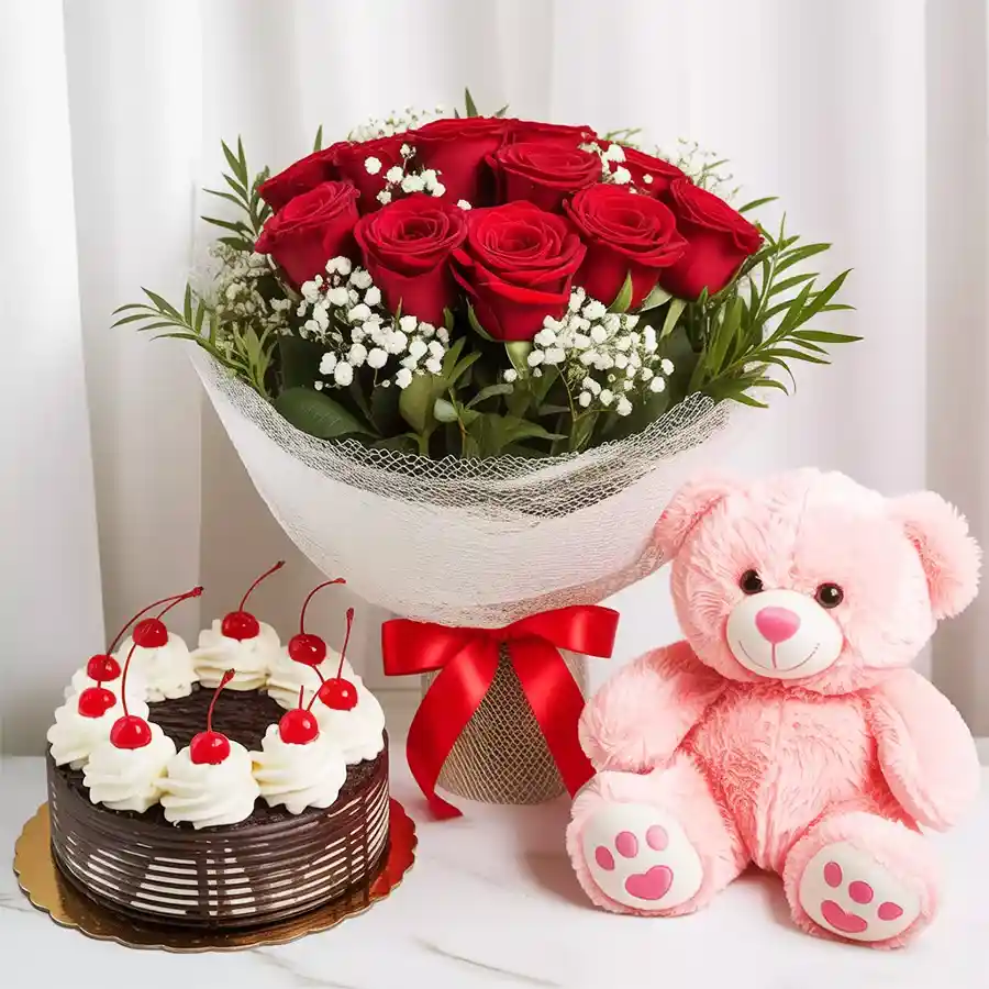 Anniversary gift of 10 red roses, a Black Forest cake, and a small teddy bear.