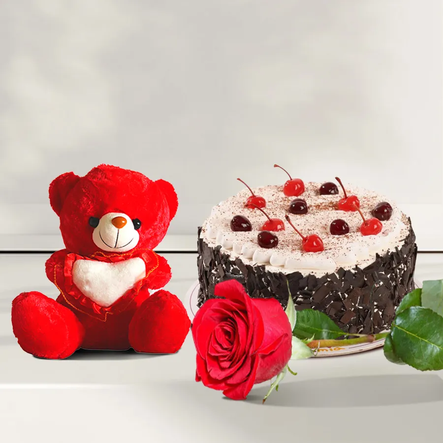 Enchanting Celebration Trio Gift Set featuring a red rose, Black Forest cake, and a small teddy bear.