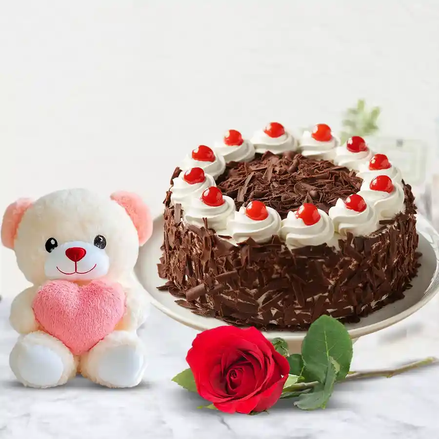 Heartfelt gift trio featuring Black Forest cake, teddy bear, and red rose.