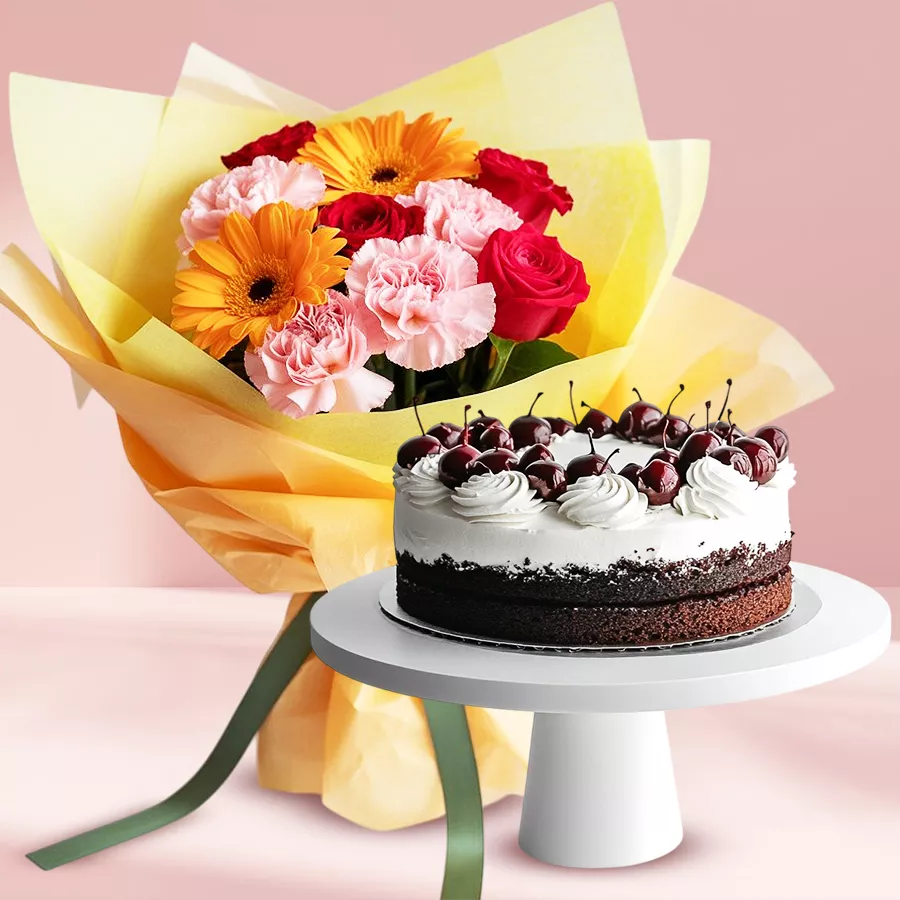 A beautiful gift hamper featuring a mixed flower bouquet with Gerberas, Carnations, Roses, and a delicious 1 lb Black Forest Cake.