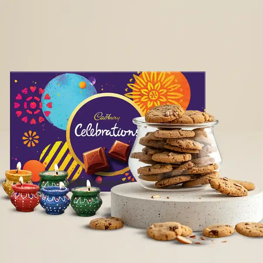 Diwali gift combo featuring assorted cookies, Cadbury chocolates, and decorative diyas.