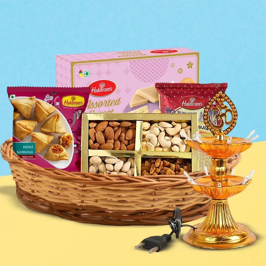 A beautifully arranged Diwali gift hamper featuring assorted dry fruits, Haldirams sweets, savory snacks, and a decorative LED lamp.