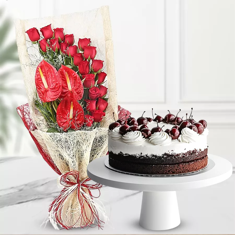 A captivating floral bouquet of red roses and Anthodium, alongside a delicious 1Lb Black Forest cake, creating a lovely gift set.