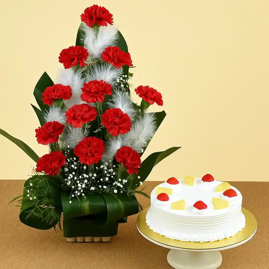 Bouquet of 12 red carnations accompanied by a round pineapple cake.
