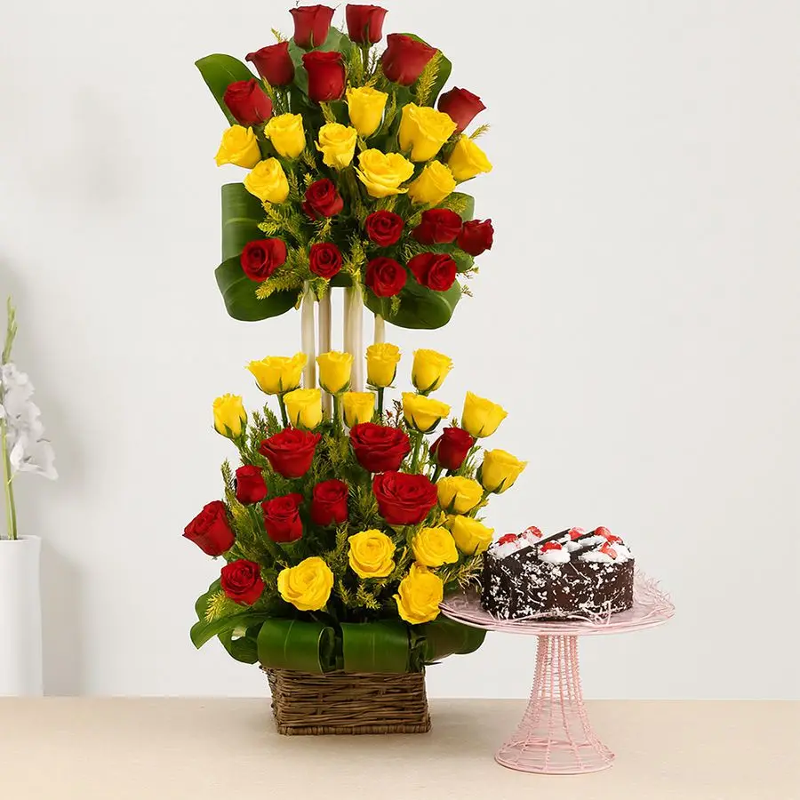 A tall basket arrangement of 50 mixed roses in red and yellow, paired with a round Black Forest cake, ideal for expressing love and celebration.