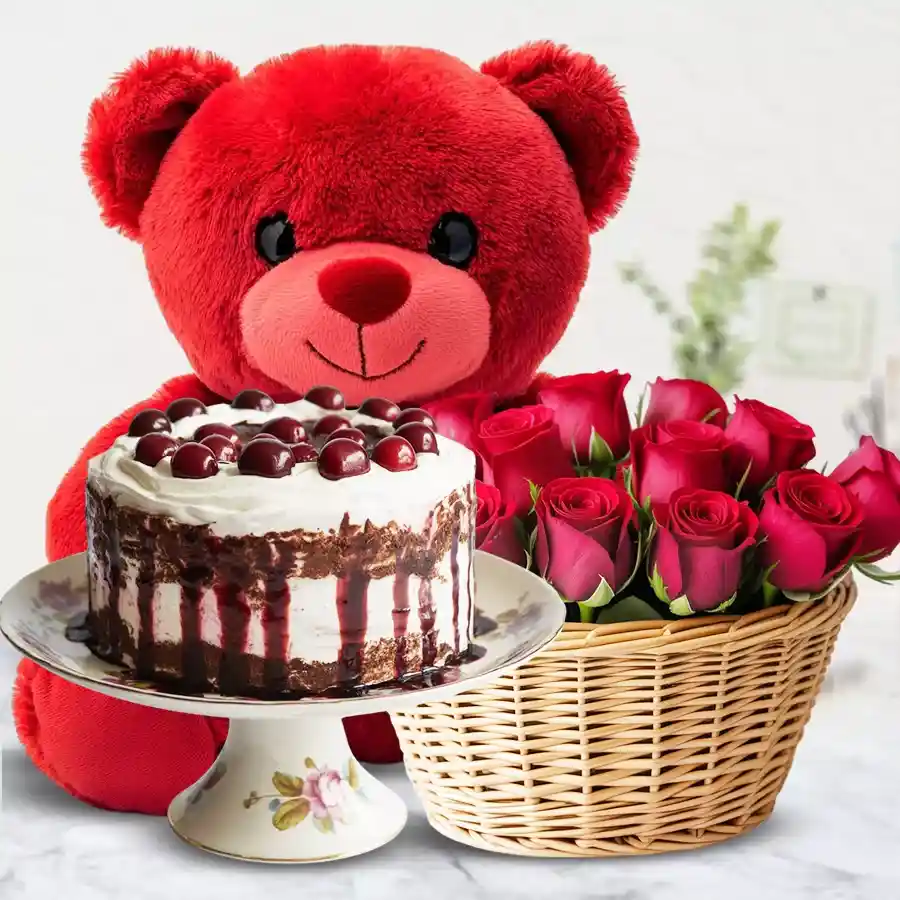 A vibrant basket of red roses, a delicious Black Forest cake, and a cute red teddy bear for a joyful celebration.