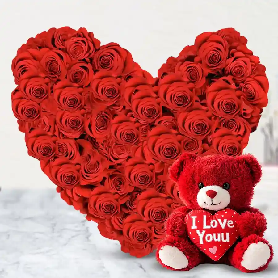 Heart-shaped arrangement of 50 red roses with a red teddy bear holding a heart that says "I Love You."
