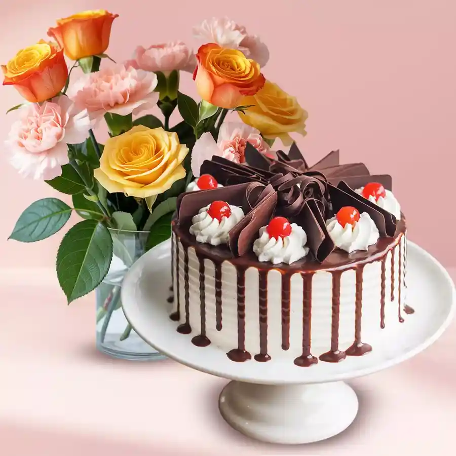 A beautiful floral vase filled with orange roses, pink carnations, and yellow roses, accompanied by a delicious half kg eggless Black Forest cake.