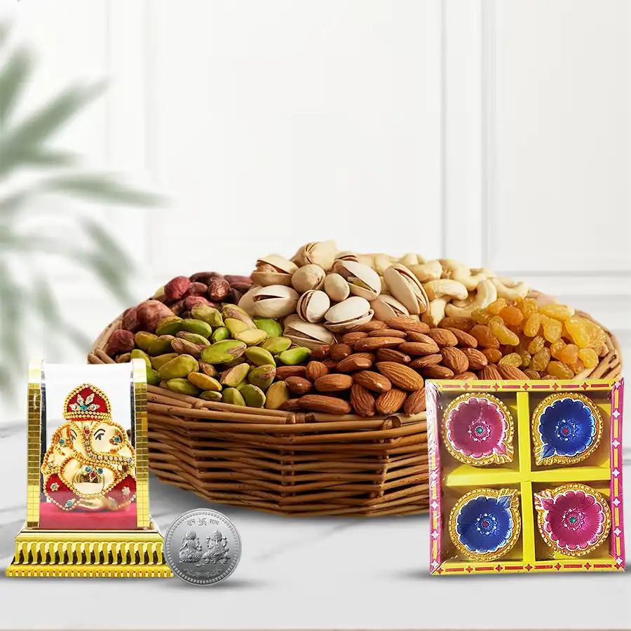 A beautifully arranged Diwali basket with premium dry fruits, a Ganesh idol, decorative diyas, and a silver Laxmi Ganesh coin.