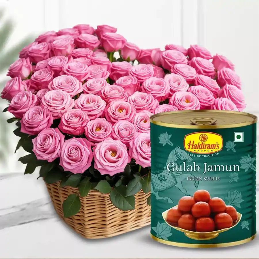 Heart-shaped basket filled with 100 pink roses and 12 Haldiram Gulab Jamun pieces, a perfect gift combination.