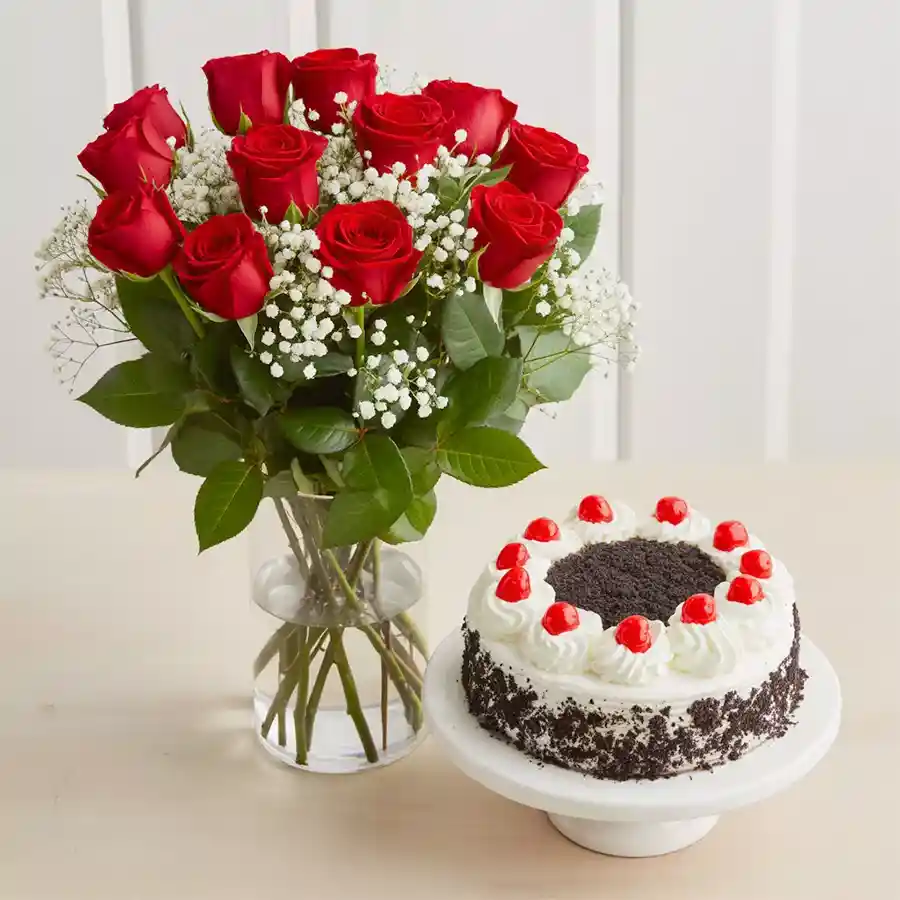A beautiful arrangement of 12 red roses in a vase alongside a half-kilogram black forest cake, ideal for celebrating special moments.