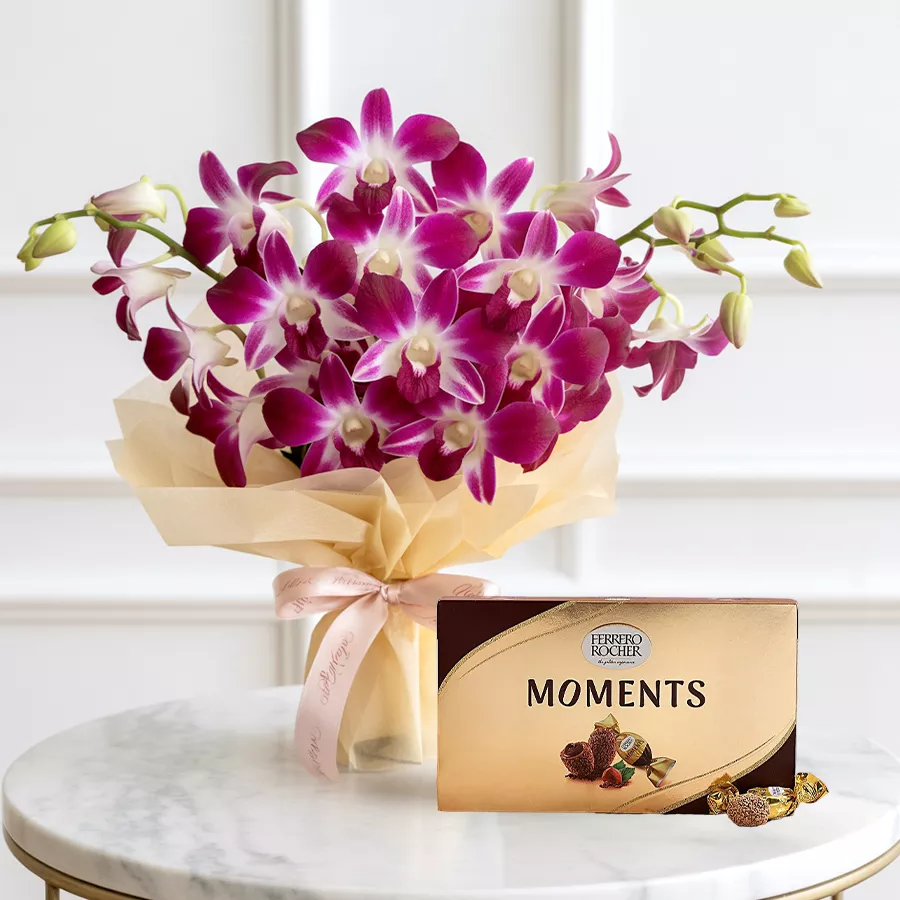 A vibrant bunch of six purple orchids accompanied by a Ferrero Rocher Moments chocolate box.