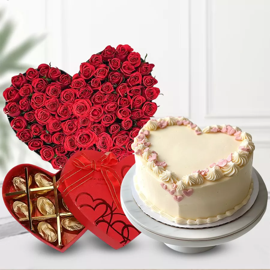 Heart-shaped arrangement of red roses with heart-shaped cake and chocolate box.