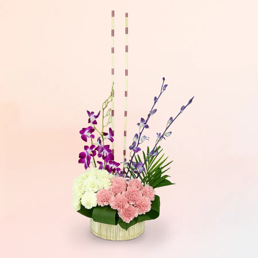 Tall basket arrangement featuring pink and white carnations and purple orchids, ideal for expressing love on special occasions.