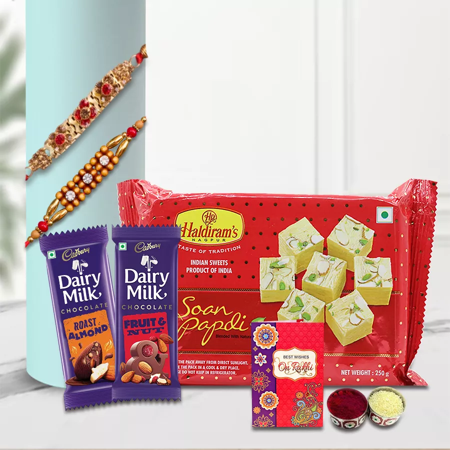 Exquisite festive sweets and chocolate gift hamper with two rakhis, a Rakhi card, and traditional Roli Tilak Chawal