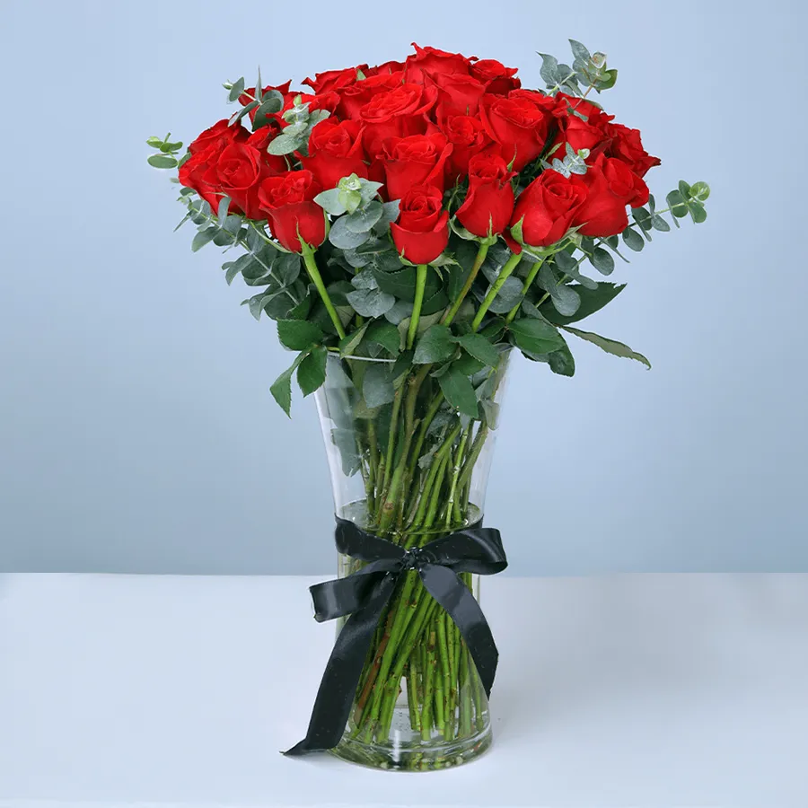 15 romantic red roses elegantly arranged in a glass vase.