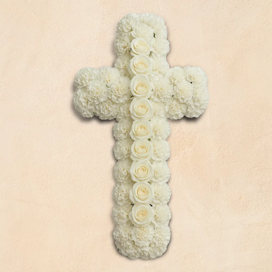 Floral arrangement featuring a cross made of 50 white carnations and 10 white roses, symbolizing remembrance and respect.