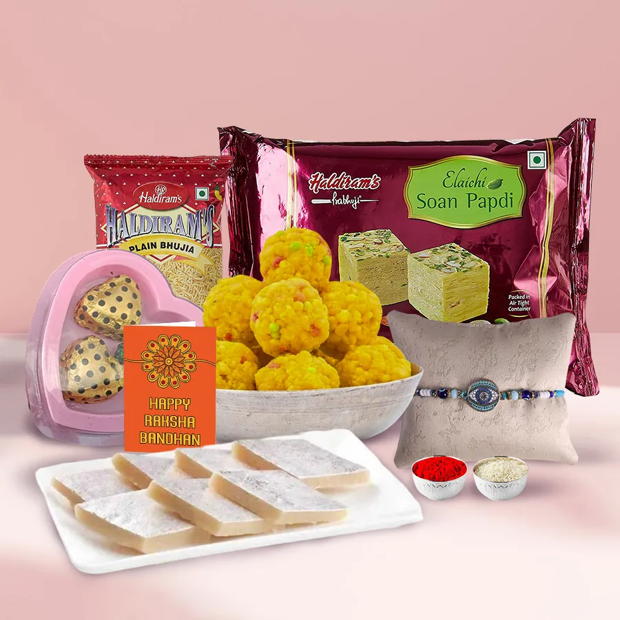 Haldiram Delightful Combo featuring 250g Soan Papdi, 250g Kaju Katli, 250g Bhujia, 750ml Thandai, and 3 homemade chocolates in a heart-shaped box.