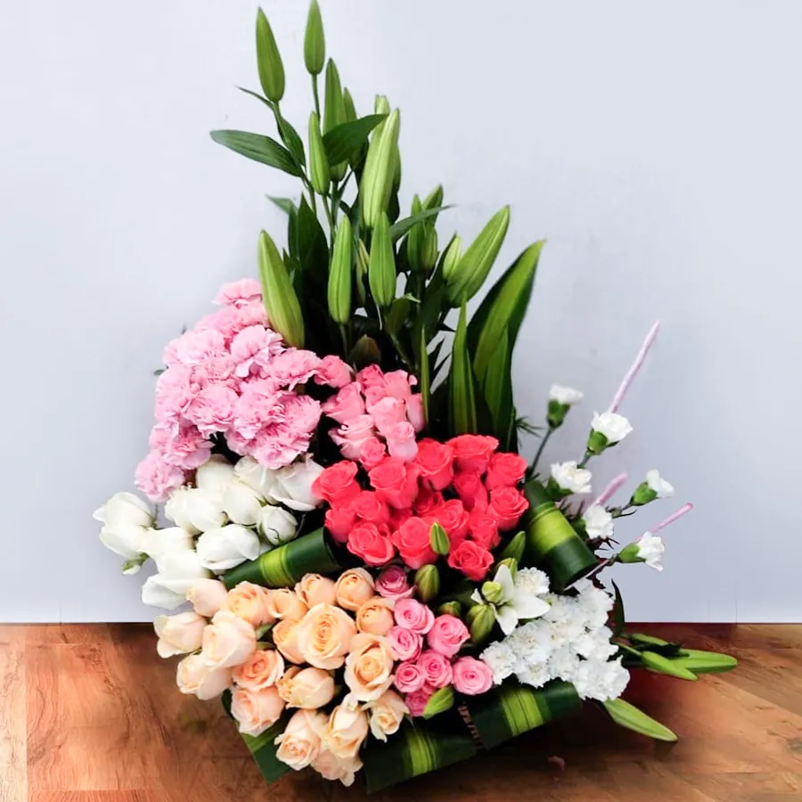 Artistic arrangement of 60 mixed color flowers including roses, carnations, and lily buds.