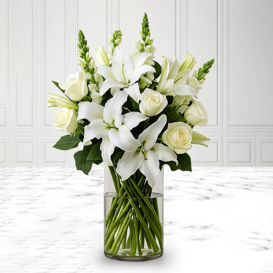 Serene white flowers including Rajnigandha, Lily, and Roses in a glass vase for condolence.
