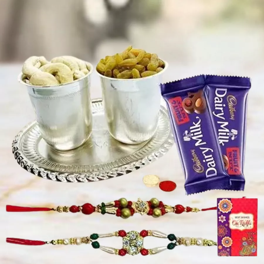 Delicious Dry Fruits Hamper featuring silver plated glasses and tray, assorted dry fruits, two Cadbury Dairy Milk Fruit & Nut bars, designer rakhis, and a personalized message card