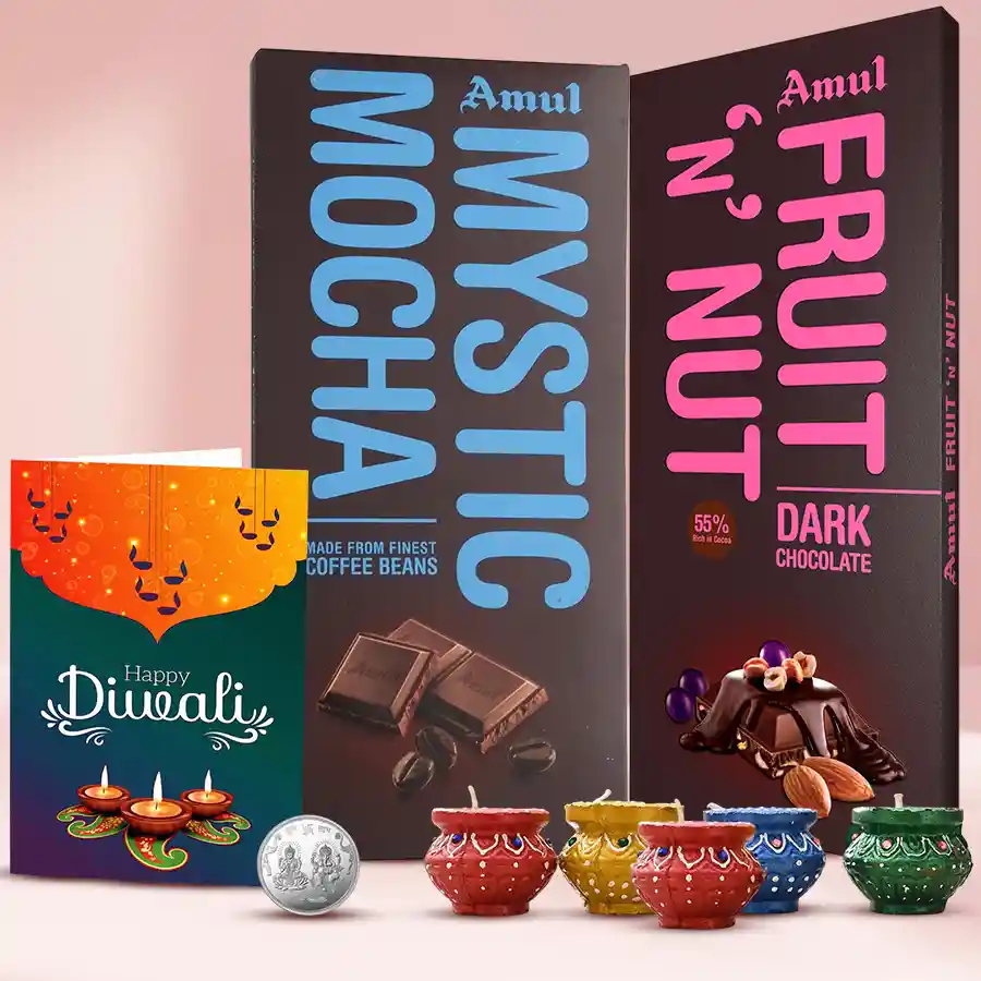 Attractive Diwali hamper featuring chocolate assortments, five decorated diyas, a silver-plated Lakshmi Ganesh coin, a Diwali greetings card, and Amul Mystic Mocha and Frut n Nut chocolate bars.