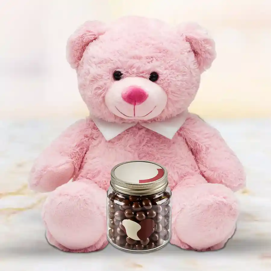 6 inch Teddy bear next to a glass jar filled with Cadbury Nutties