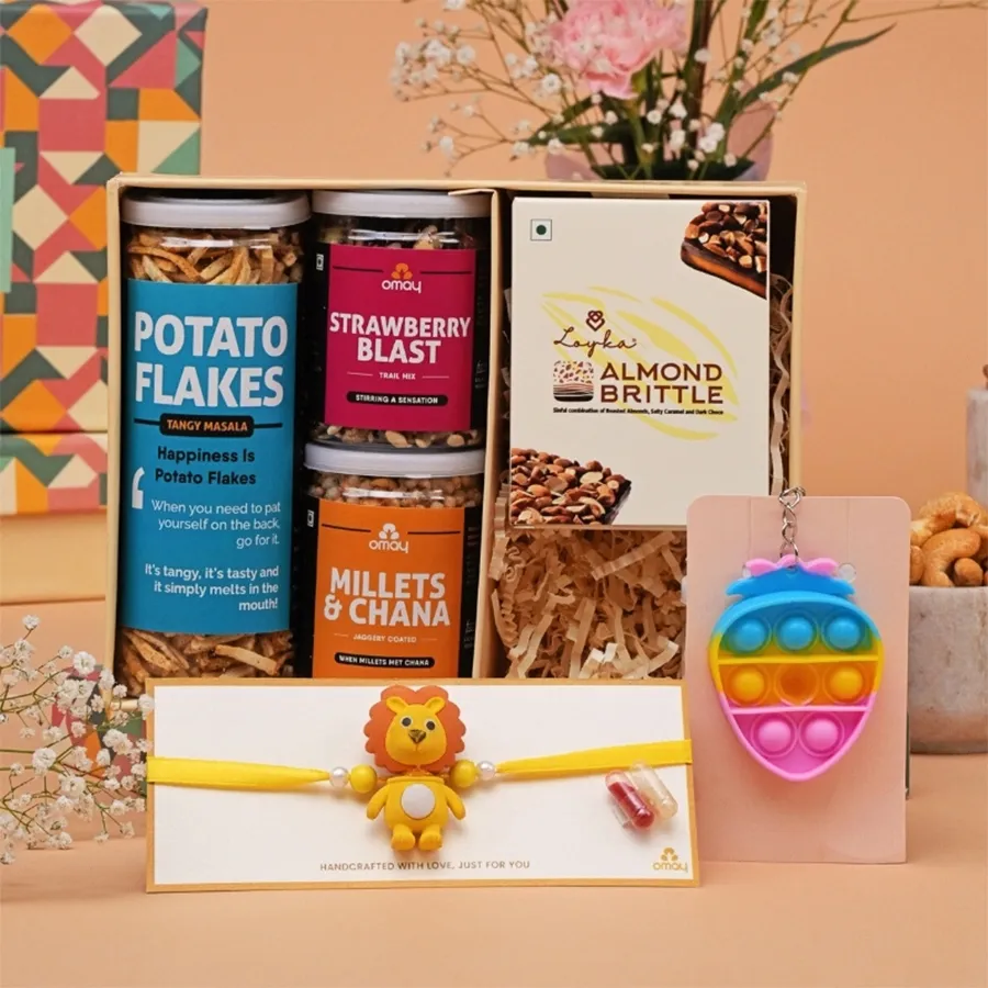 Joyful Rakhi Treats for Kids gift hamper with snacks, a handmade rakhi, and a keychain in a premium gift box.