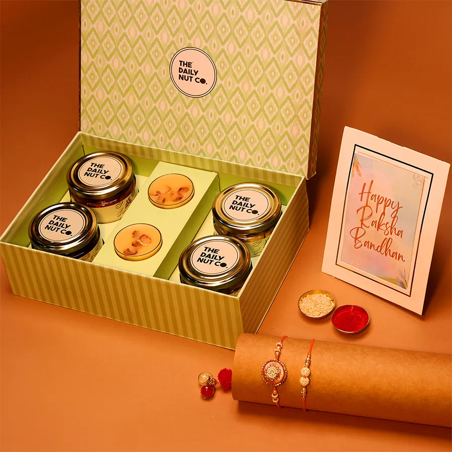 Wholesome Rakhi Celebration Gift Box featuring nuts, protein snacks, and candles for a joyful sibling celebration.