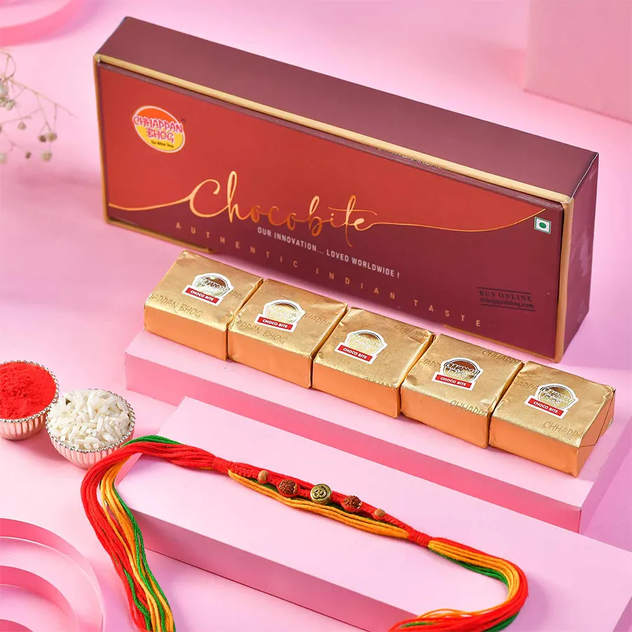 The Rakhi Harmony with Choco Treats Set -- a divine Rakhi with an Om Rudraksh design, accompanied by Chappan Bhog Chocobites and a Roli Chawal Card, symbolizing love and tradition.