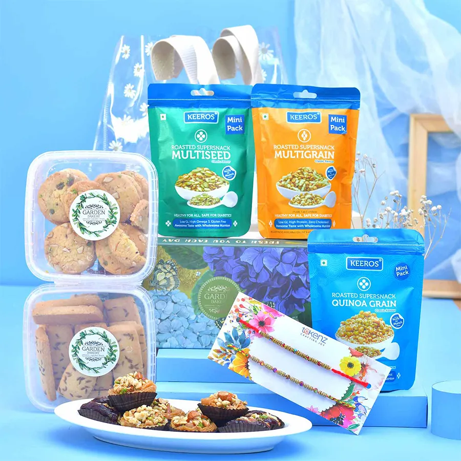 Sibling Rakhi & Gourmet Treats Basket featuring rakhis, cookies, snacks, and a floral gift bag for festive celebrations.