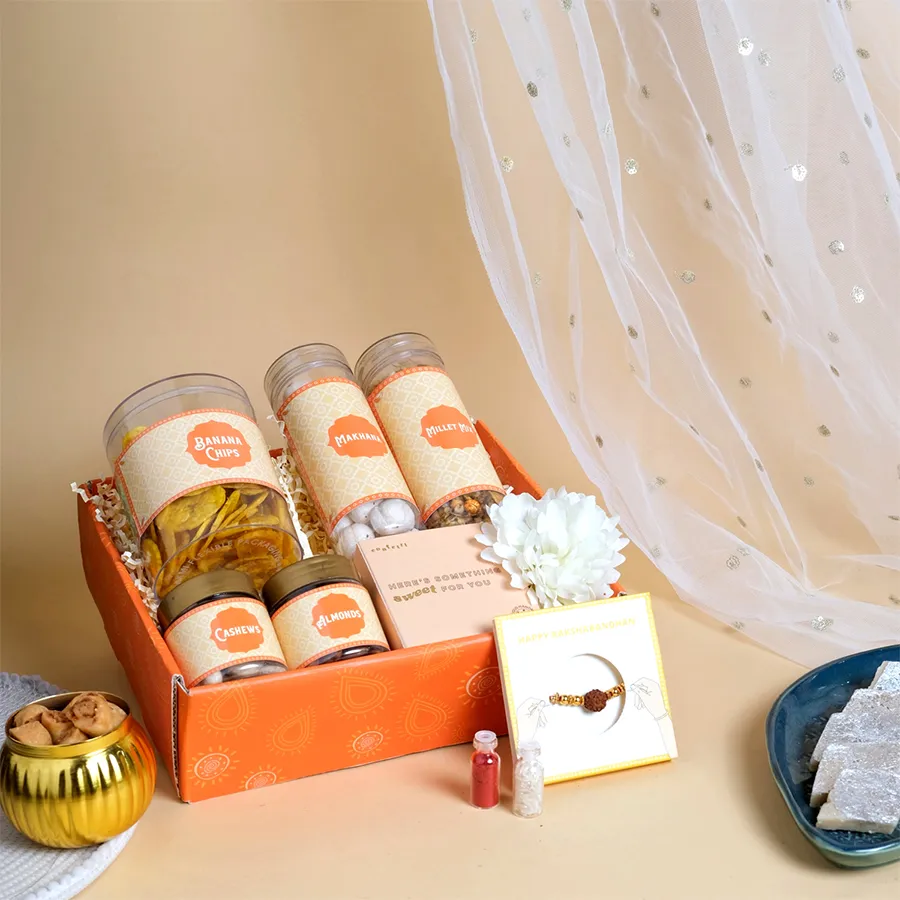 Festive Rakhi & Nibbles Delight Pack with Rudraksha Rakhi and various snacks in a beautiful tray.