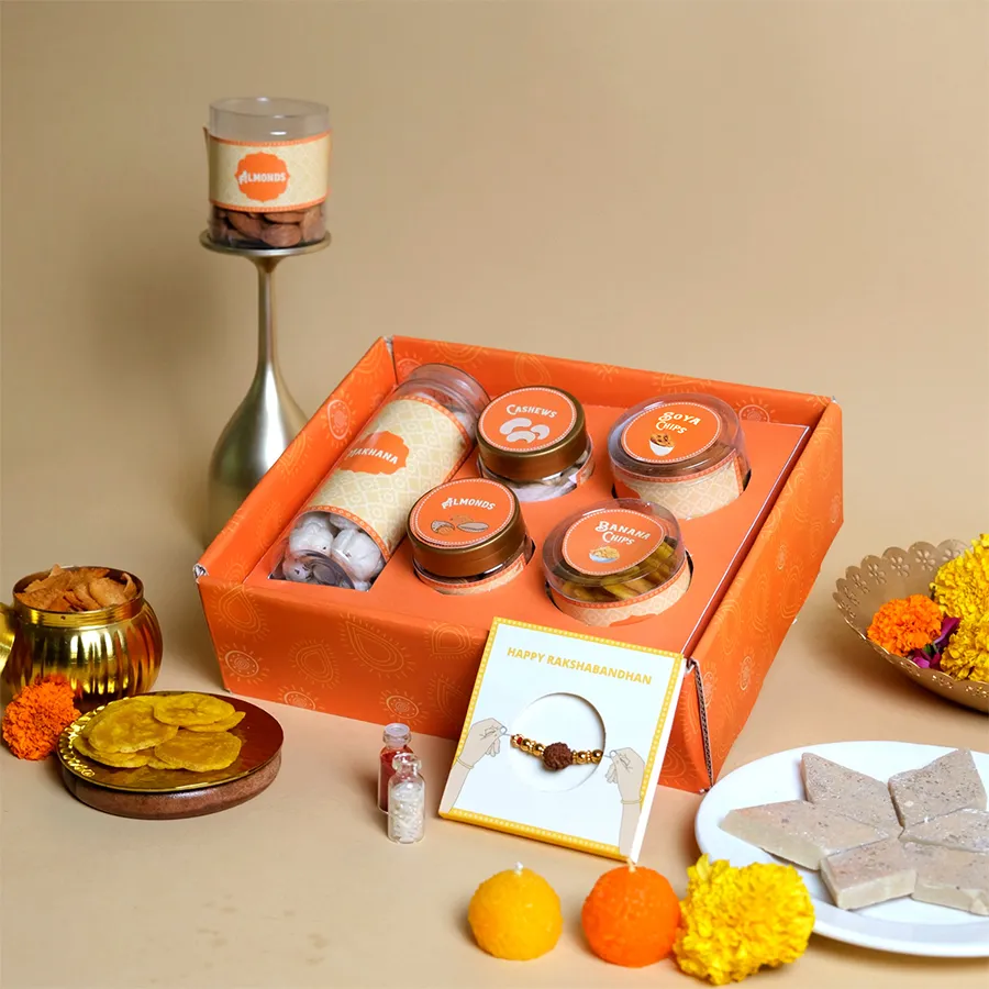 Wholesome Crunch & Rakhi Delight Pack featuring Rudraksha Rakhi and assorted snacks in a festive tray.