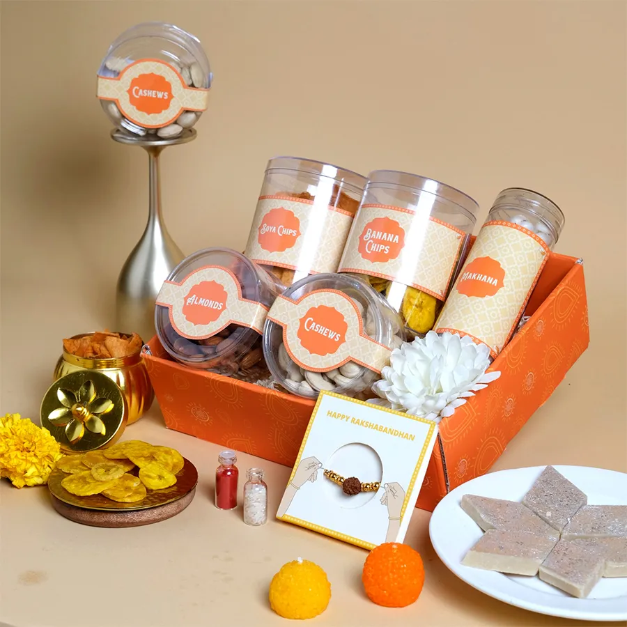 Festive Munchies Rakhi Surprise Box featuring a Rudraksha Rakhi and assorted snacks in a decorative tray.