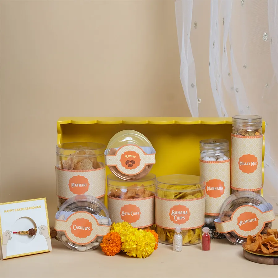 Festive Flavors Rakhi Snack Tray featuring assorted treats, Rudraksha Rakhi, and a vibrant yellow tray for celebrations.