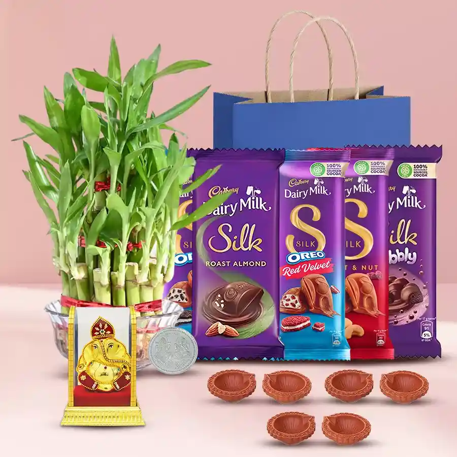 Environment-friendly Diwali gift hamper featuring Cadbury chocolates, a Lucky Bamboo plant, a Vighnesh Ganesh idol, six designer mud diyas, and a silver-plated Ganesh-Laxmi coin, all packaged in a reusable gift bag.