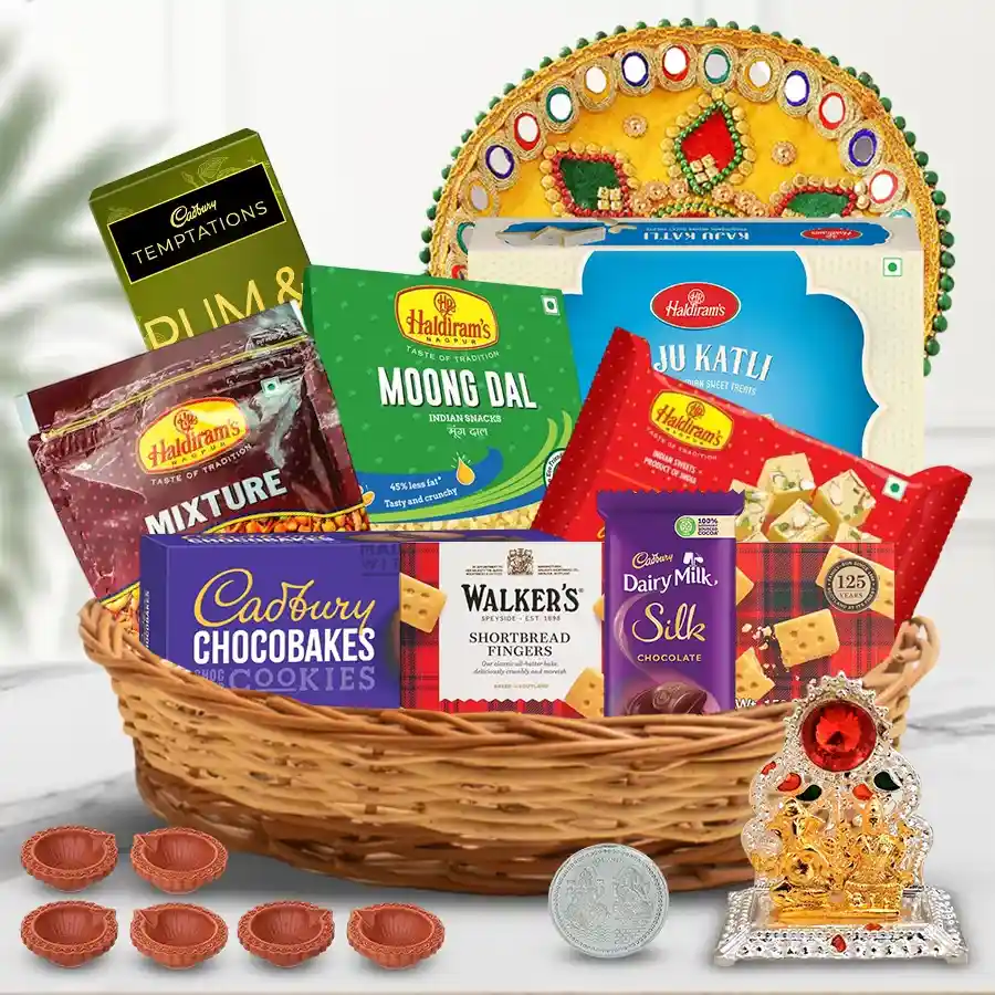 Delightful Assortments Gift Hamper for Diwali featuring sweets, savory treats, a designer pooja thali, mud diyas, and Ganesh-Laxmi décor, wrapped in a cane basket.