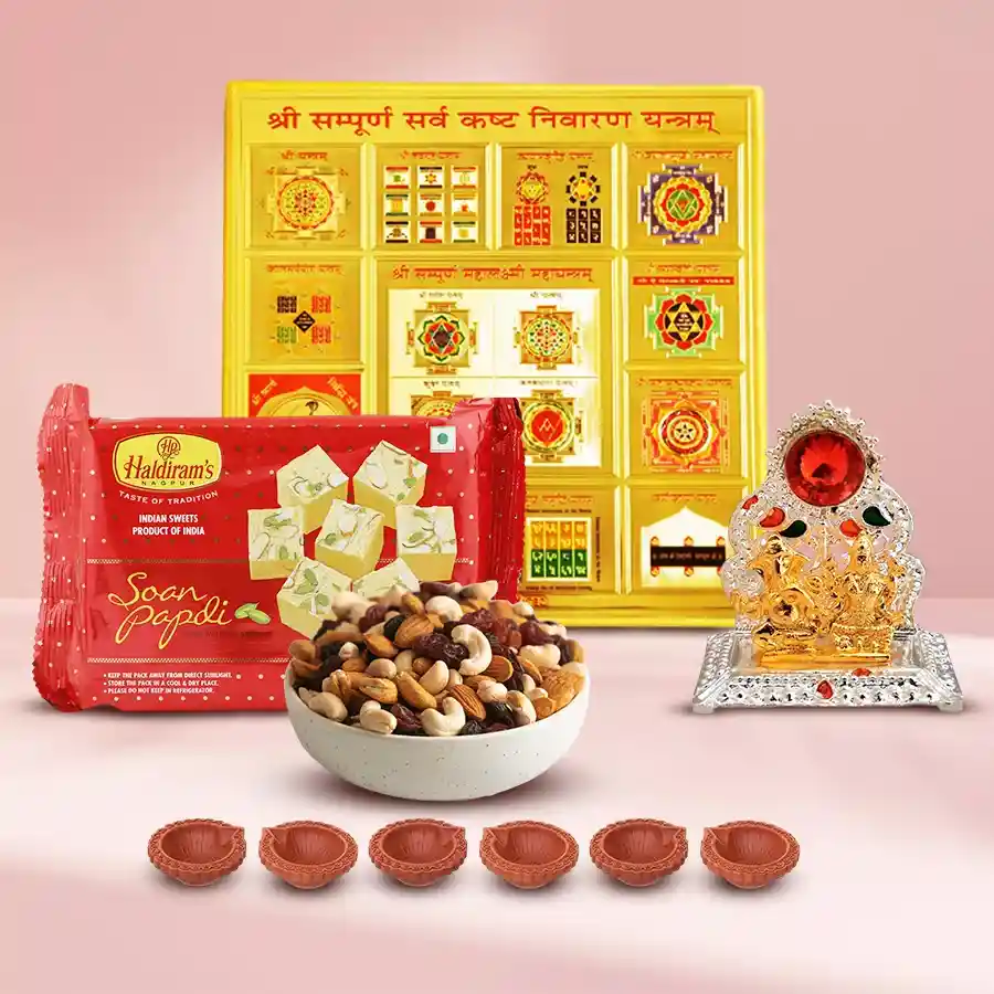 Auspicious Sarva Kashta Nivaran Yantra Combo featuring gold brass Yantra, Lakshmi Ganesh Mandap, Haldirams Soan Papdi, assorted dry fruits, and decorative diyas arranged for Diwali celebration.